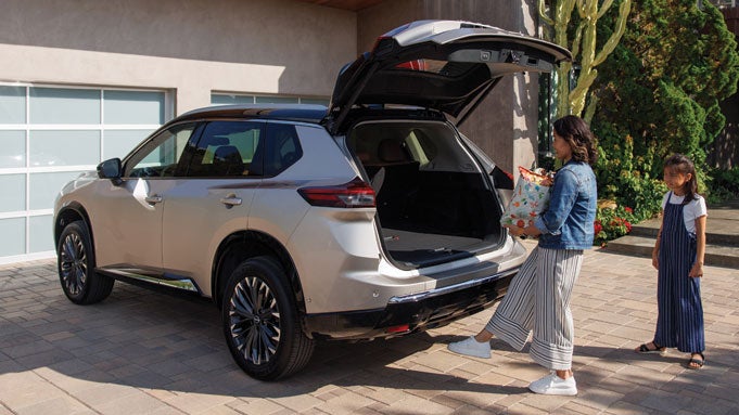 woman putting things in trunk of car
