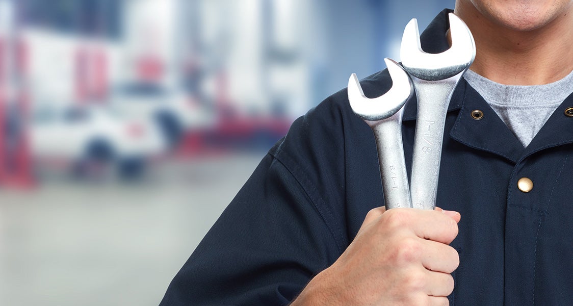 man holding two wrenches